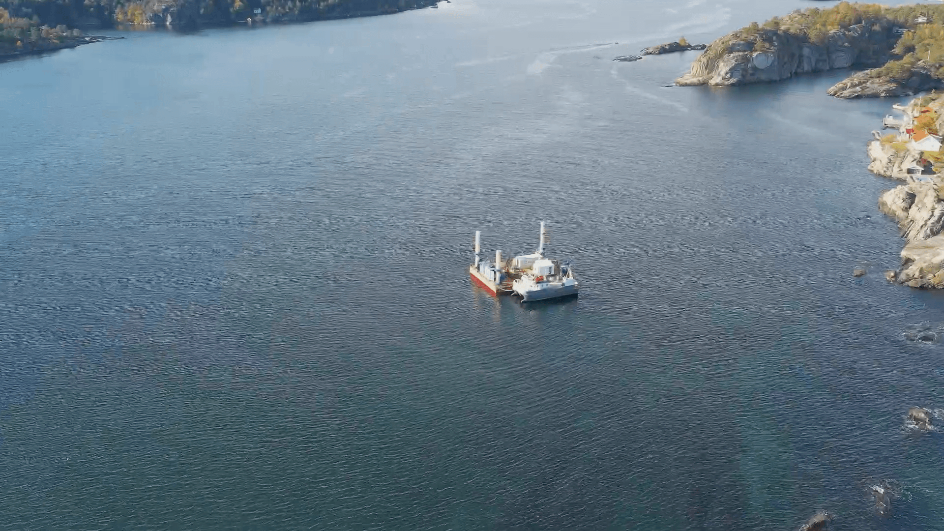 Dronebilde av en arbeidsrigg ute i vannet.